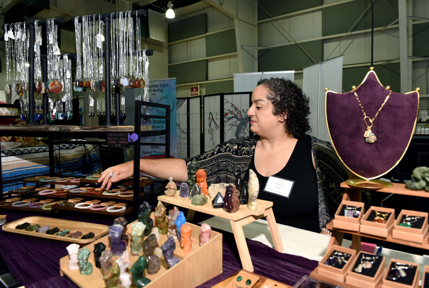 New Visions Holistic Expo Vespertine Goods vendor booth with jewelry and crystal figurines.